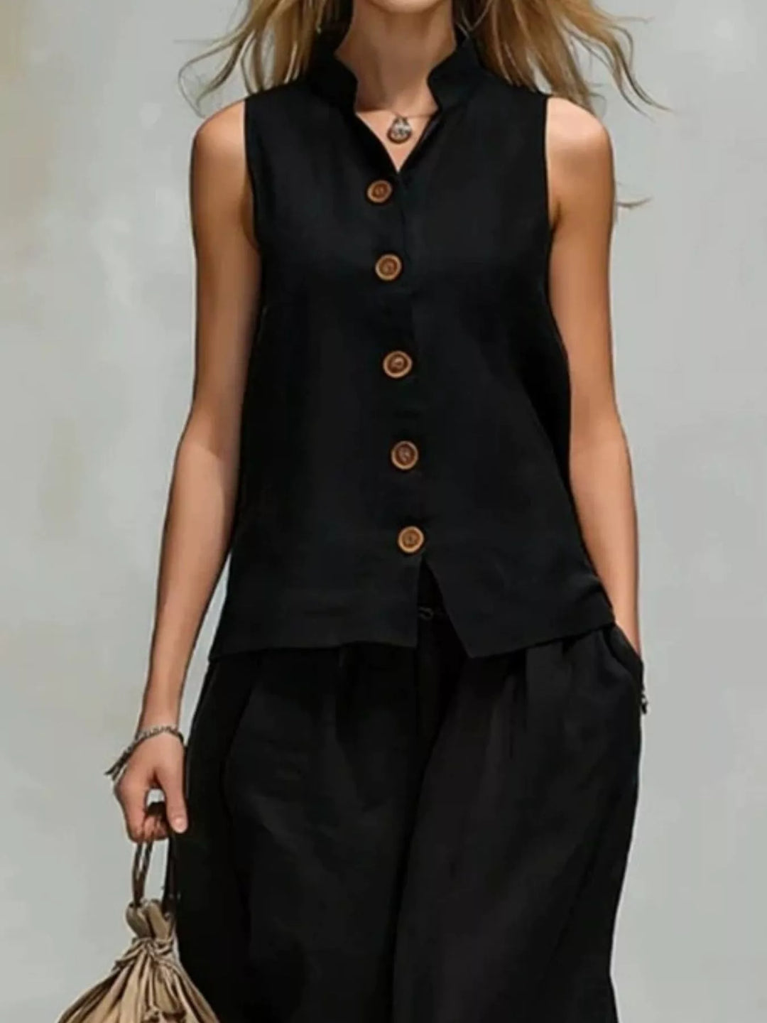 Front view of the black vest with wooden buttons and relaxed wide leg pants