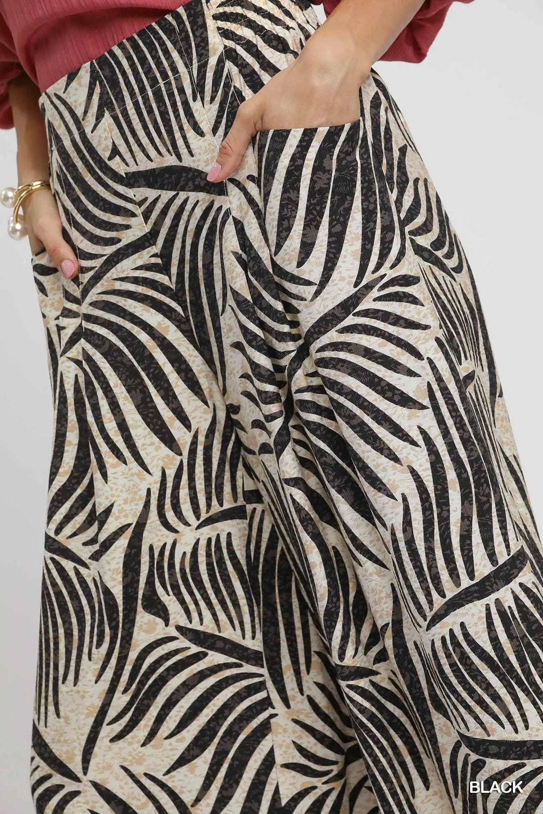 Close-up of the bold palm leaf print and side pocket on the culottes