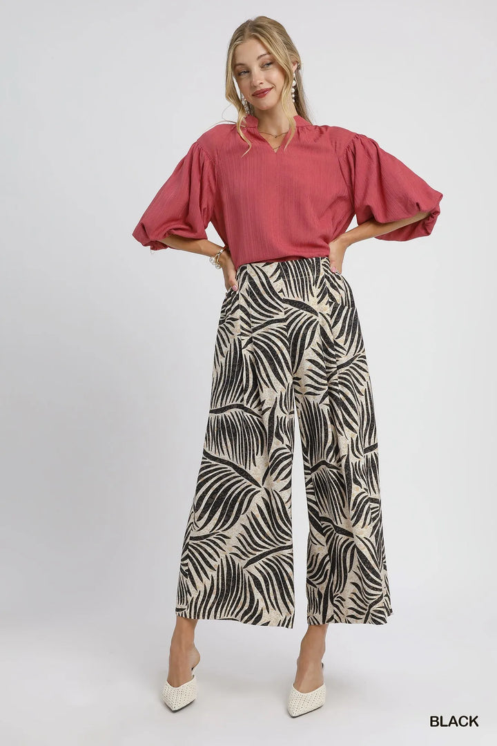 Full-length black and cream palm print culottes styled with a berry puff sleeve top