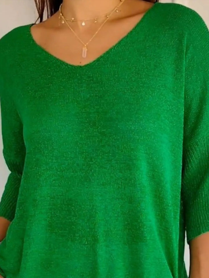Green V neck sweater neckline close-up with delicate necklaces
