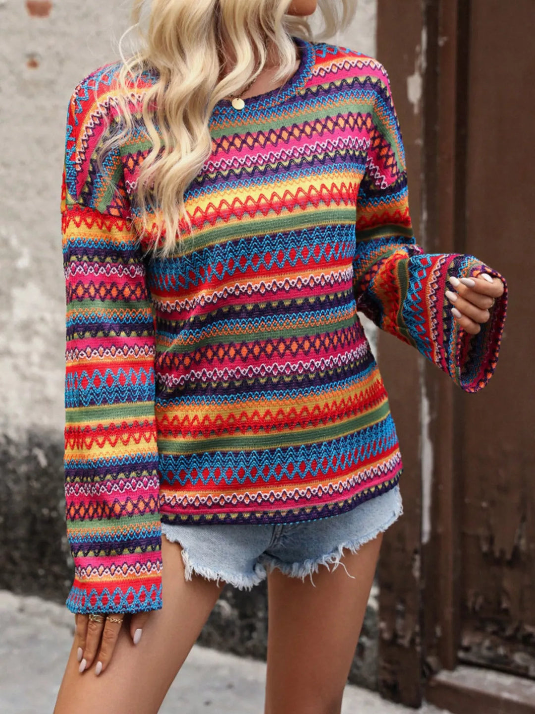 Red zigzag stripe sweater with bell sleeves, side angle with raised arm