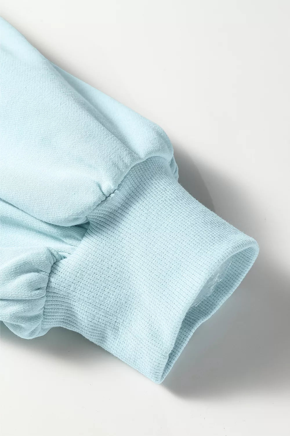 Close-up of the pastel blue pullover balloon sleeve and ribbed cuff