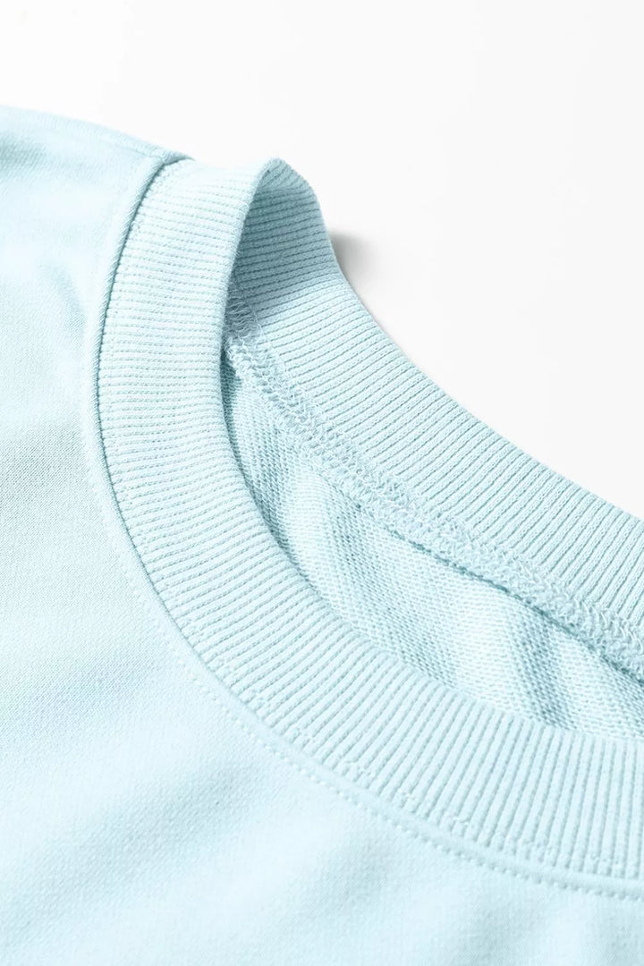 Close-up of the ribbed crew neckline on the pastel blue pullover