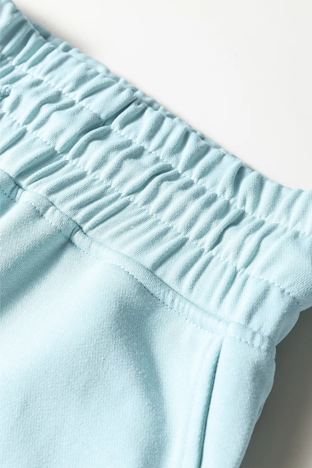 Close-up of the gathered elastic waistband on the pastel blue wide leg pants