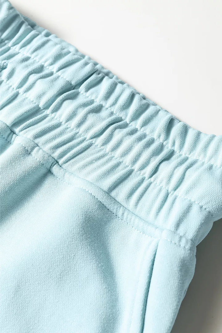 Close-up of the gathered elastic waistband on the pastel blue wide leg pants
