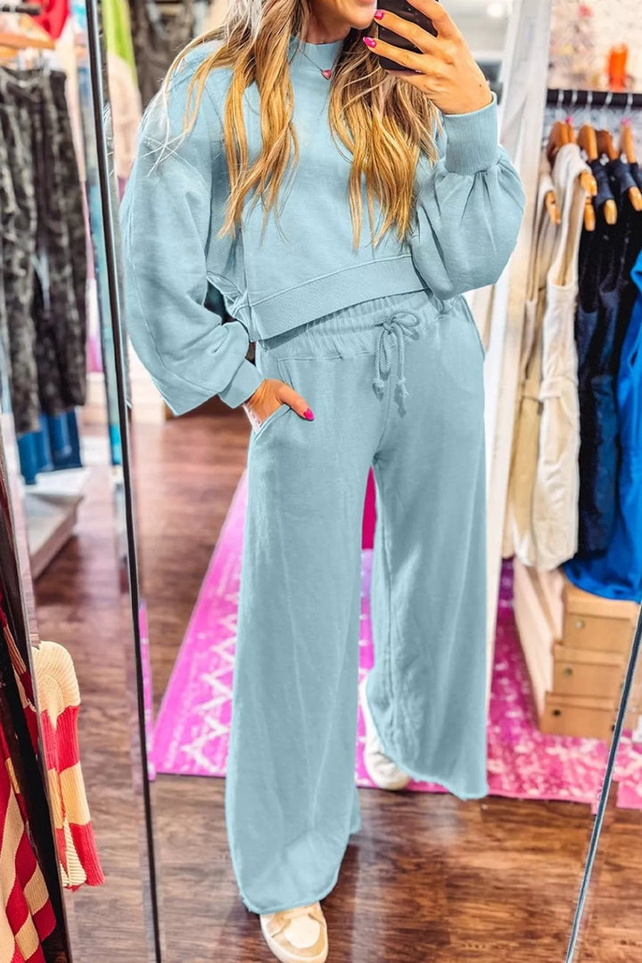 Mirror view of the pastel blue sweatsuit with hand in pocket