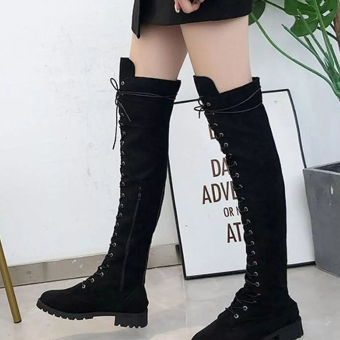 Full-length view of black lace up boots with a short skirt