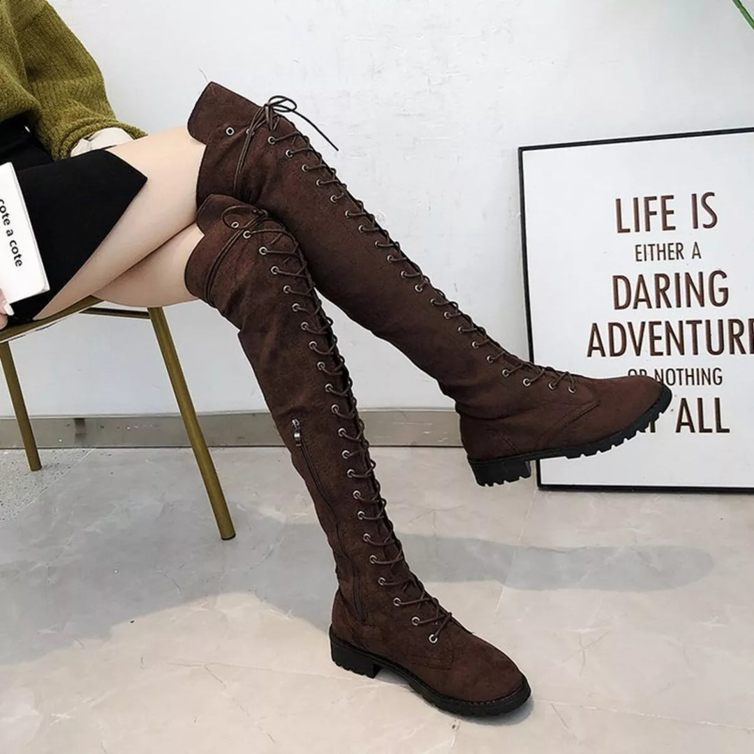Dark brown thigh high lace up boots worn seated with legs extended