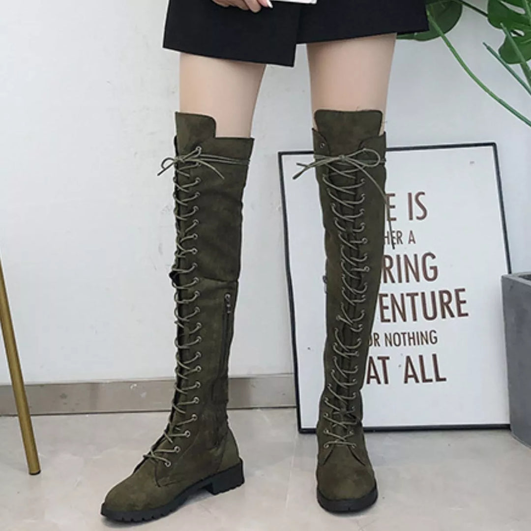 Full-length view of olive lace up boots worn with a black mini skirt