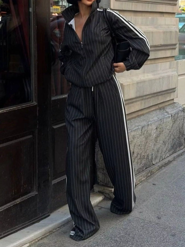 Black pinstripe tracksuit with white side stripes, standing front view