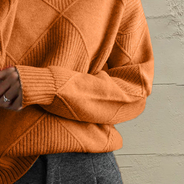 Close-up of the burnt orange geometric diamond knit sleeve and ribbed cuff