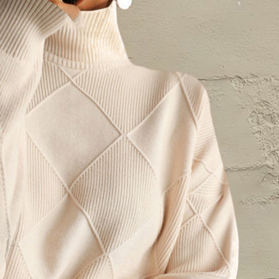 Close-up of the ivory turtleneck collar and diamond knit pattern