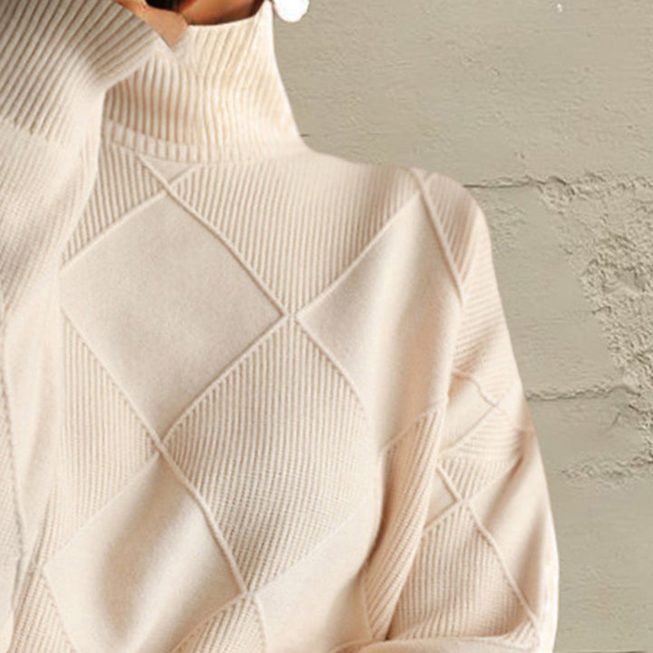 Close-up of the ivory turtleneck collar and diamond knit pattern