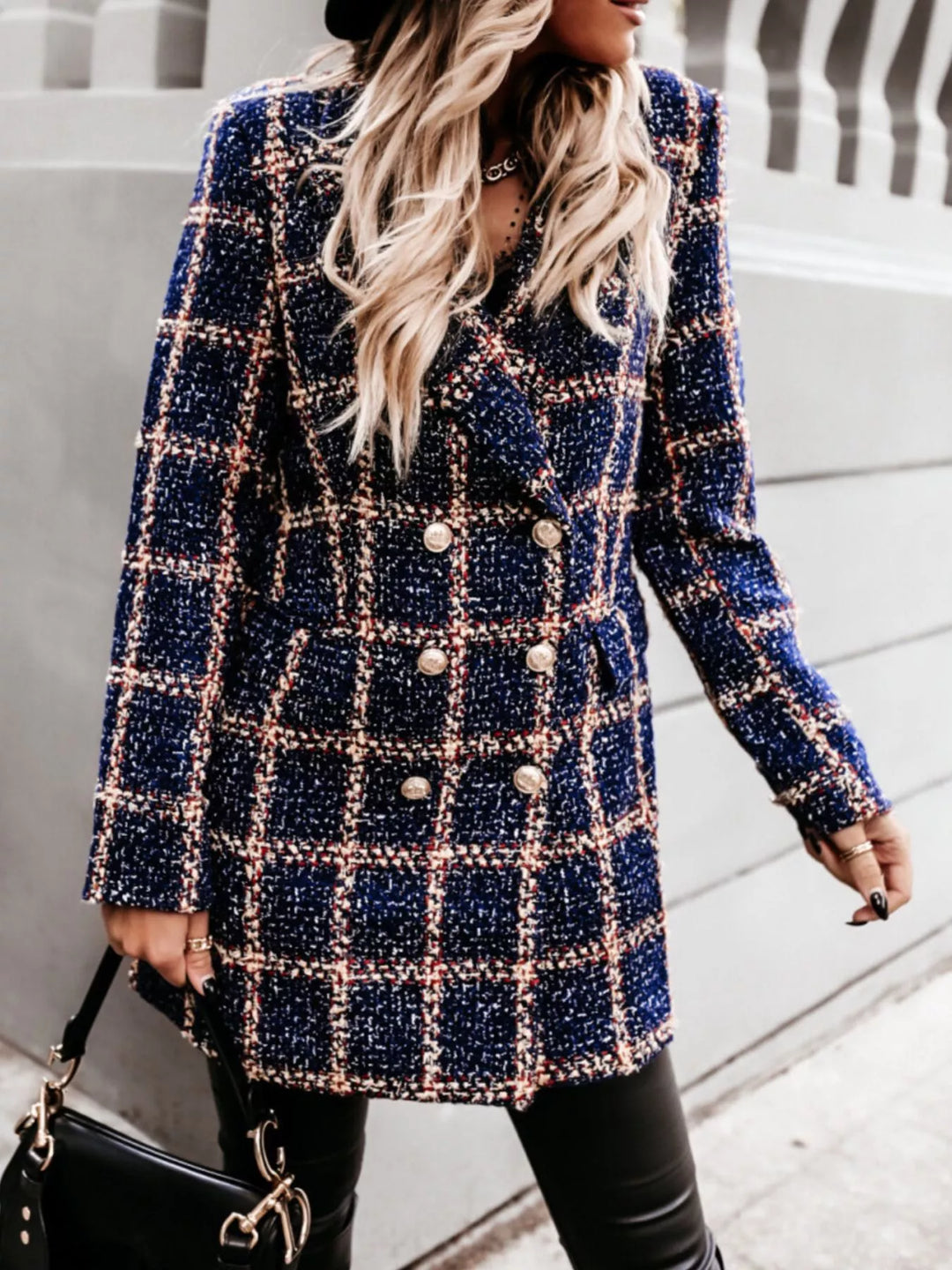 Navy plaid tweed coat in a walking pose with black handbag