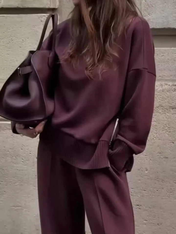 Close-up of the burgundy mock neck pullover with dropped shoulders and a tote bag
