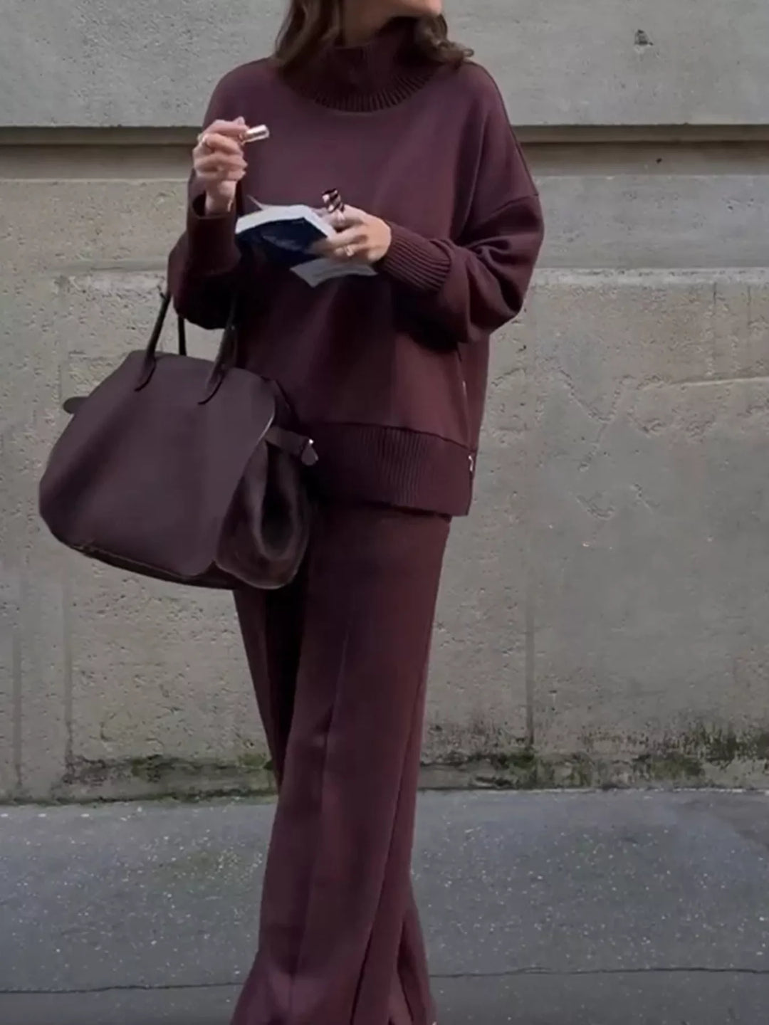Burgundy two piece set front view with hand holding a book and bag