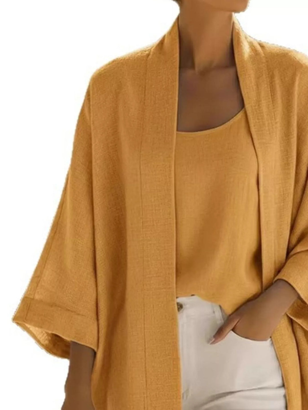 Close-up of the mustard open front cardigan and tank with hand in pocket