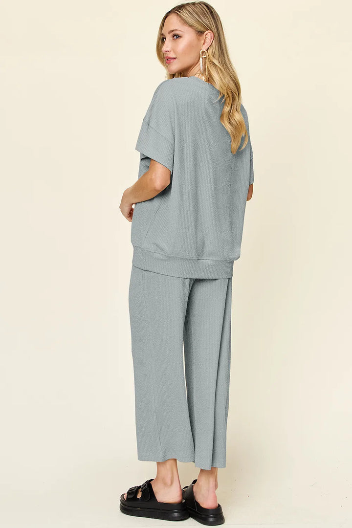 Back view of the dusty blue two piece set with chunky sandals