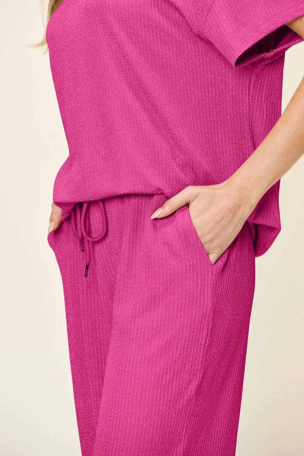 Close-up of the hot pink top hem, drawstring waist and pocket