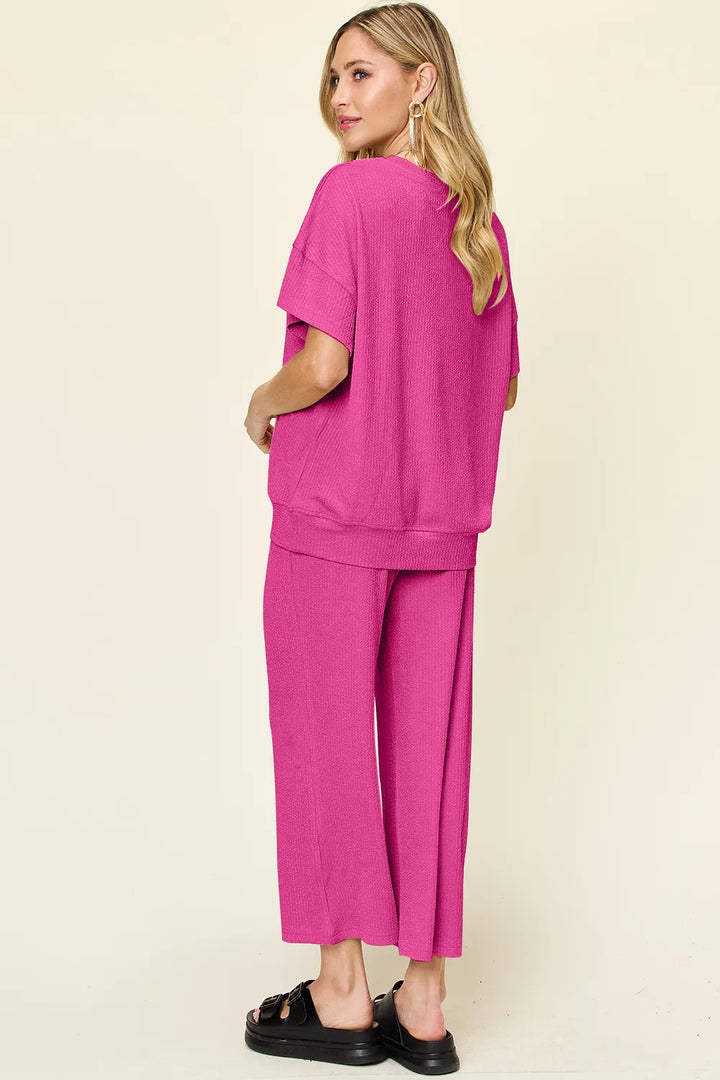 Hot pink short sleeve top and cropped pants, side angle with hand in pocket
