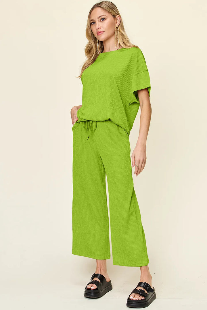 Lime green short sleeve top and cropped wide pants, front view with sandals