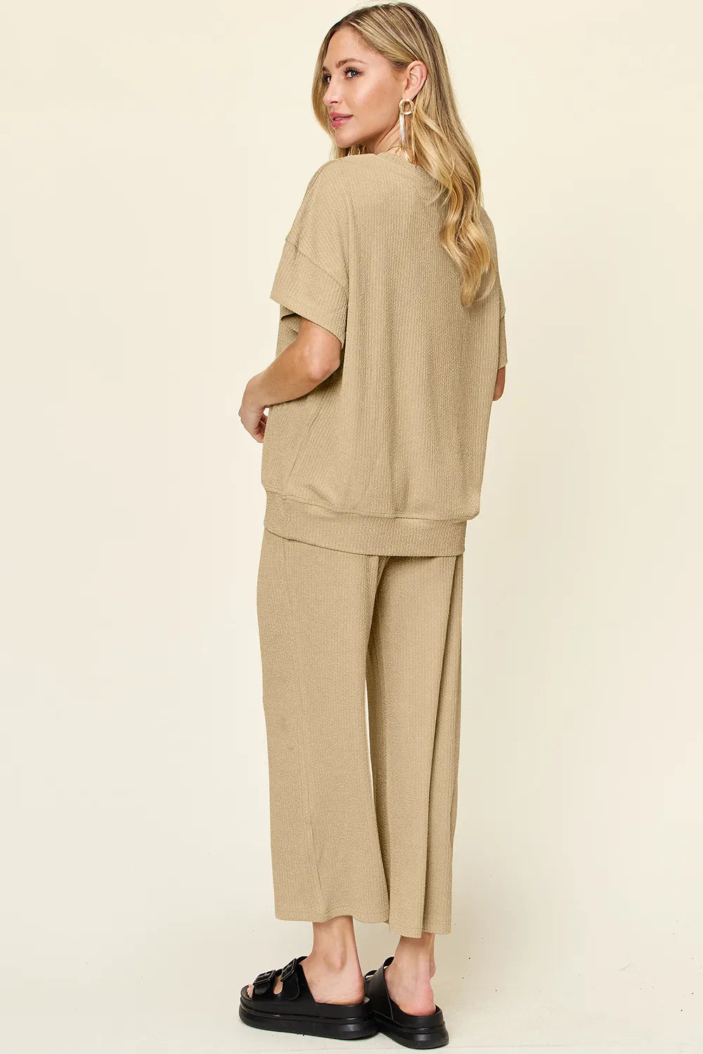Back view of the tan two piece set with black chunky sandals