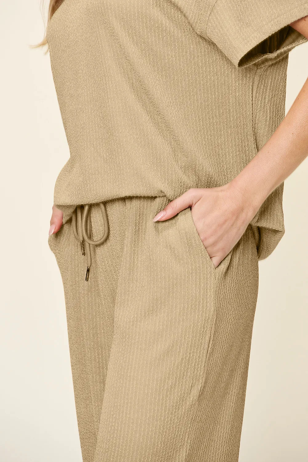 Close-up of the tan drawstring waist, top hem and pocket