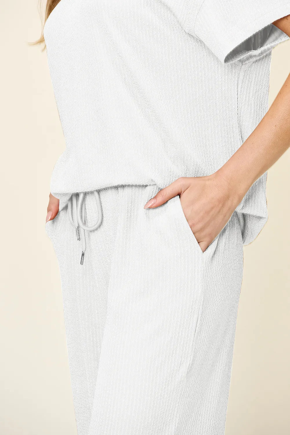 Close-up of the white drawstring waist and hand in pocket