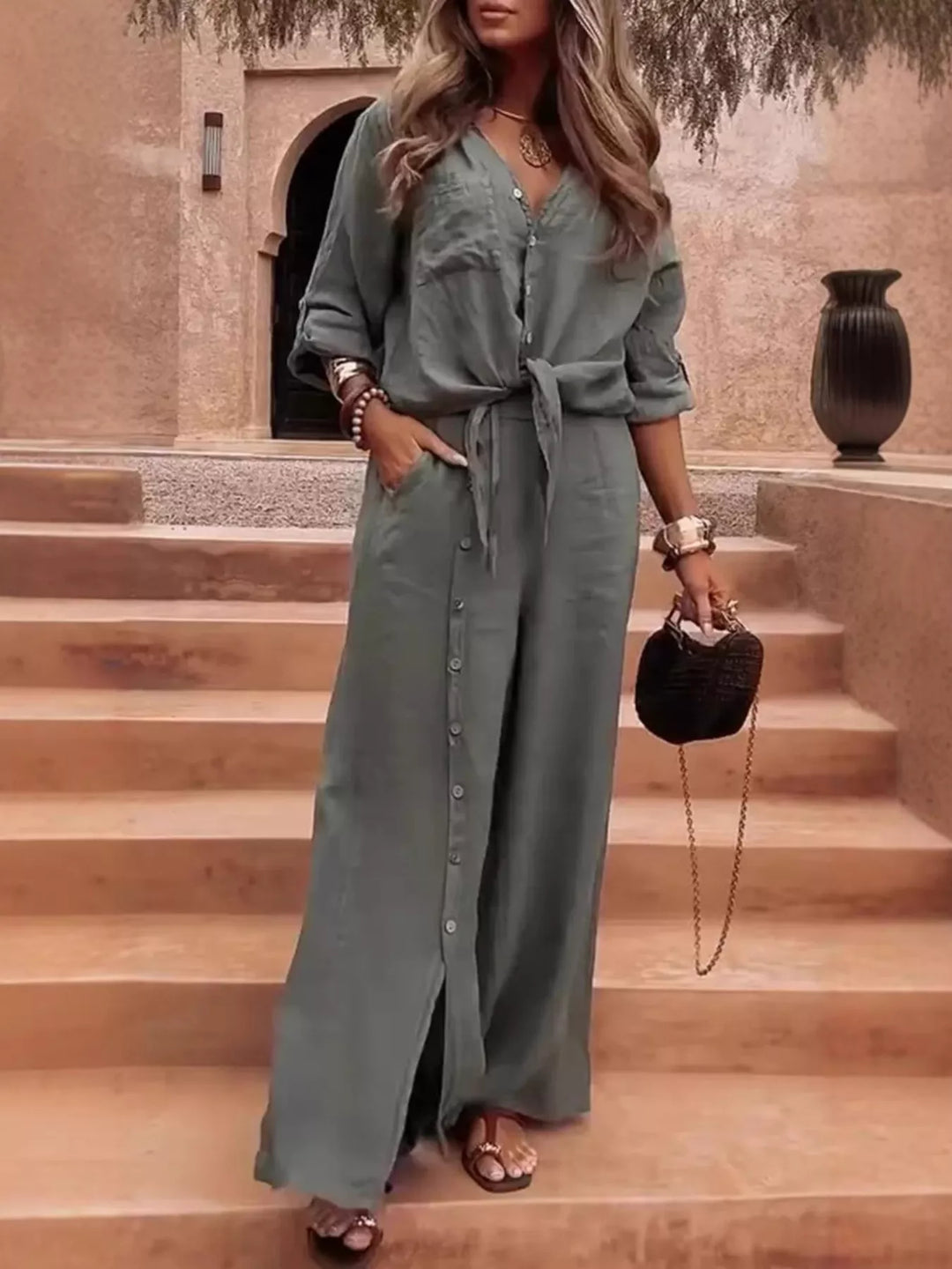 Sage green two piece set with tie front shirt and wide leg pants on terracotta steps