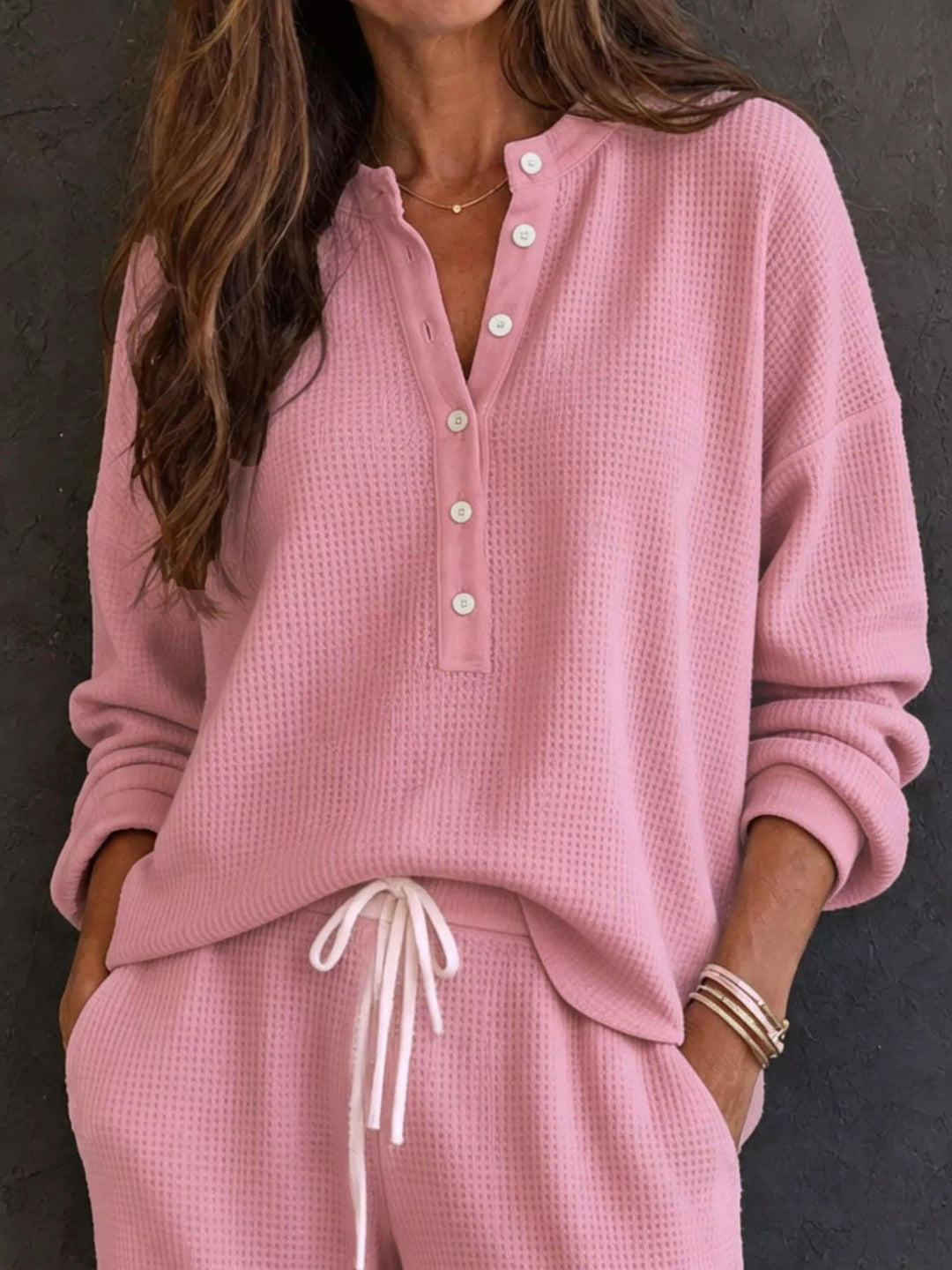 Dusty pink waffle knit henley top with button placket and drawstring pants, close-up