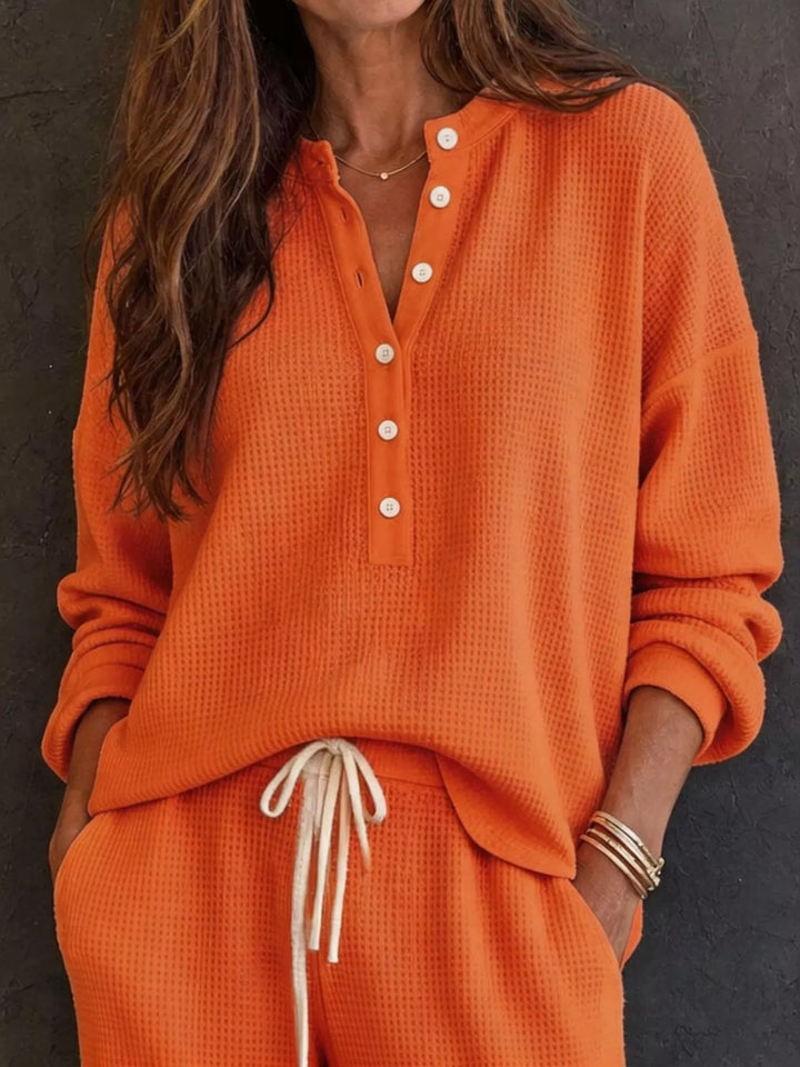 Orange waffle knit henley top with button placket and drawstring pants, close-up