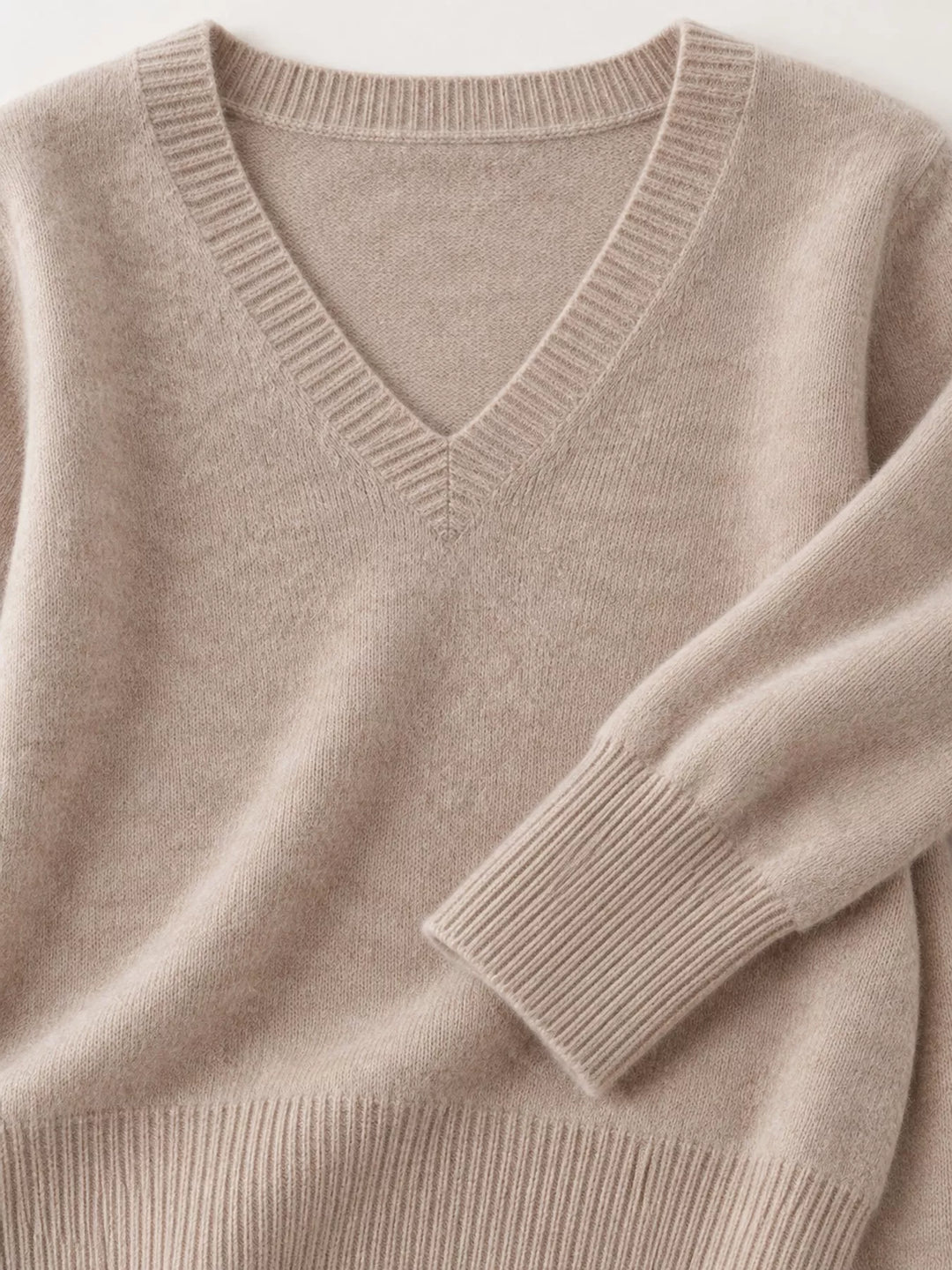 Close-up details of the light camel sweater neckline, ribbed cuff and hem