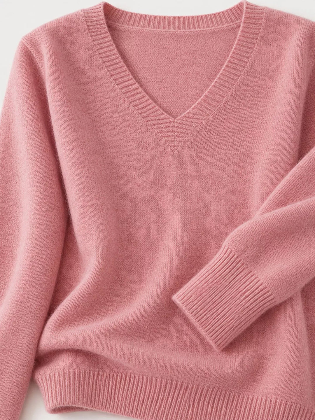 Close-up details of the pink sweater neckline, ribbed cuff and hem