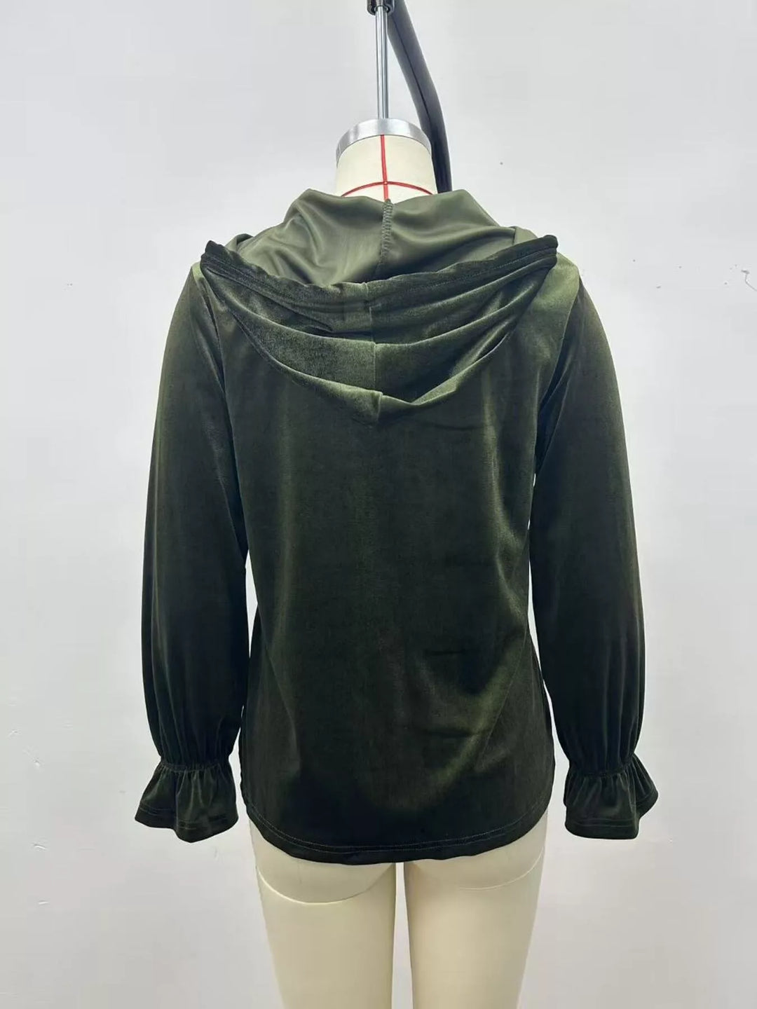 Olive green velvet jacket seen from the back with hood resting down