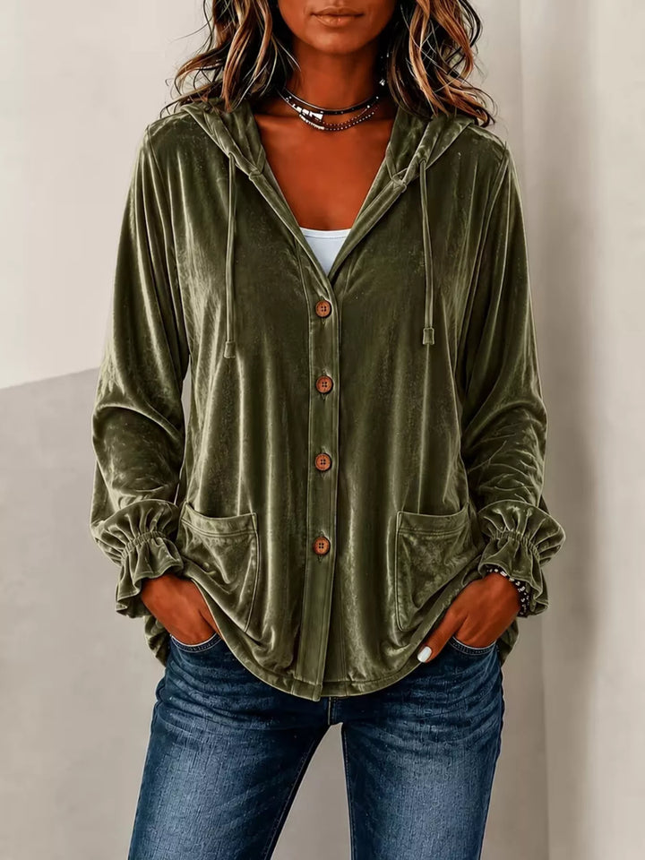 Olive green velvet jacket with button front worn with jeans and hands in pockets