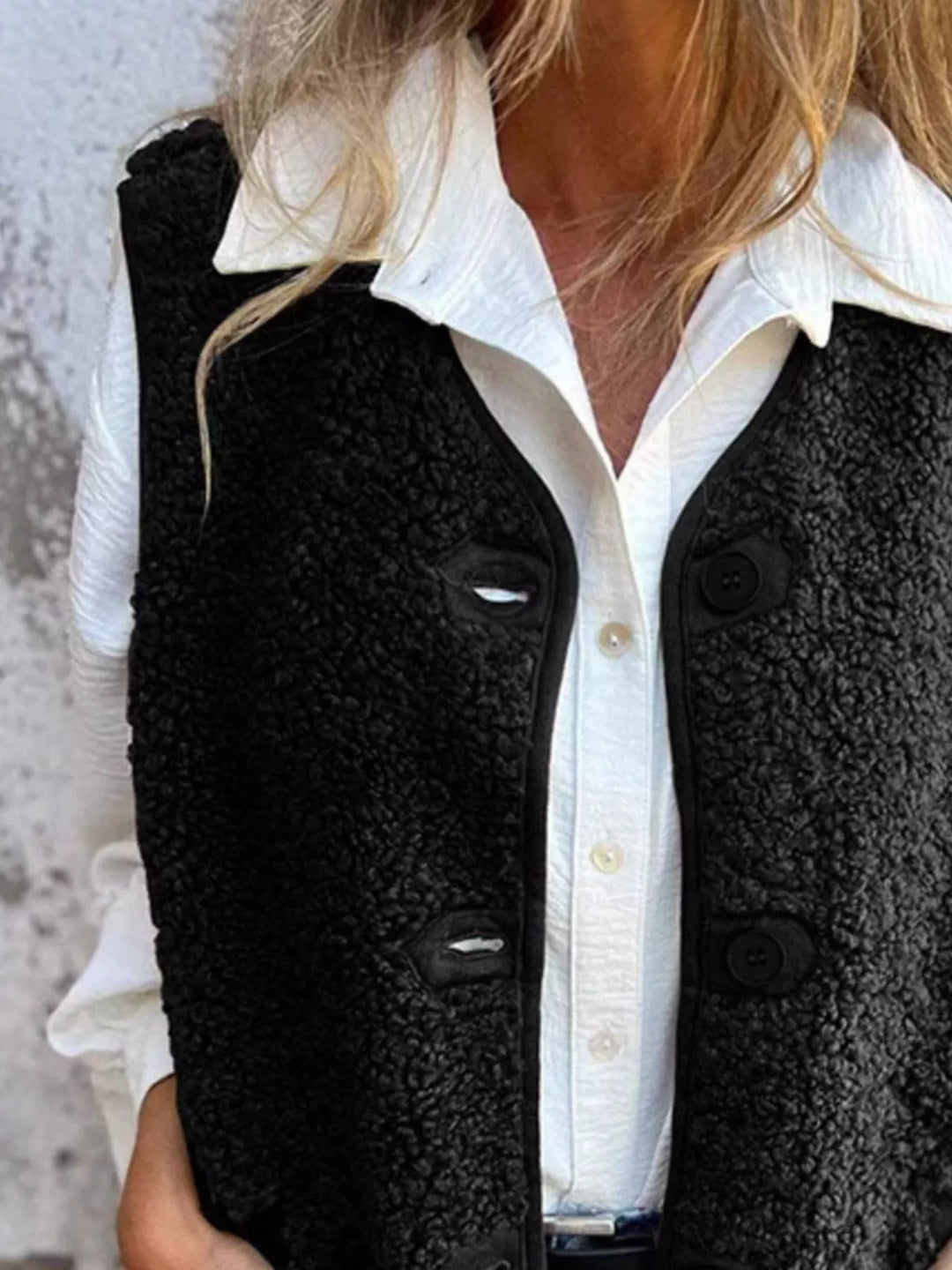 Close-up of the black textured vest front with large buttons