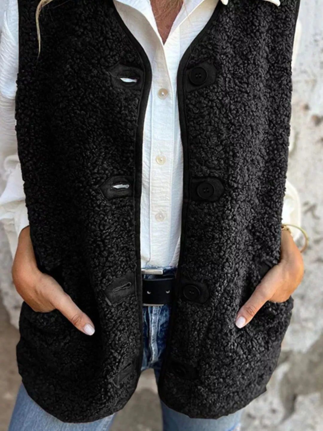 Front view of the black button front vest with hands in side pockets