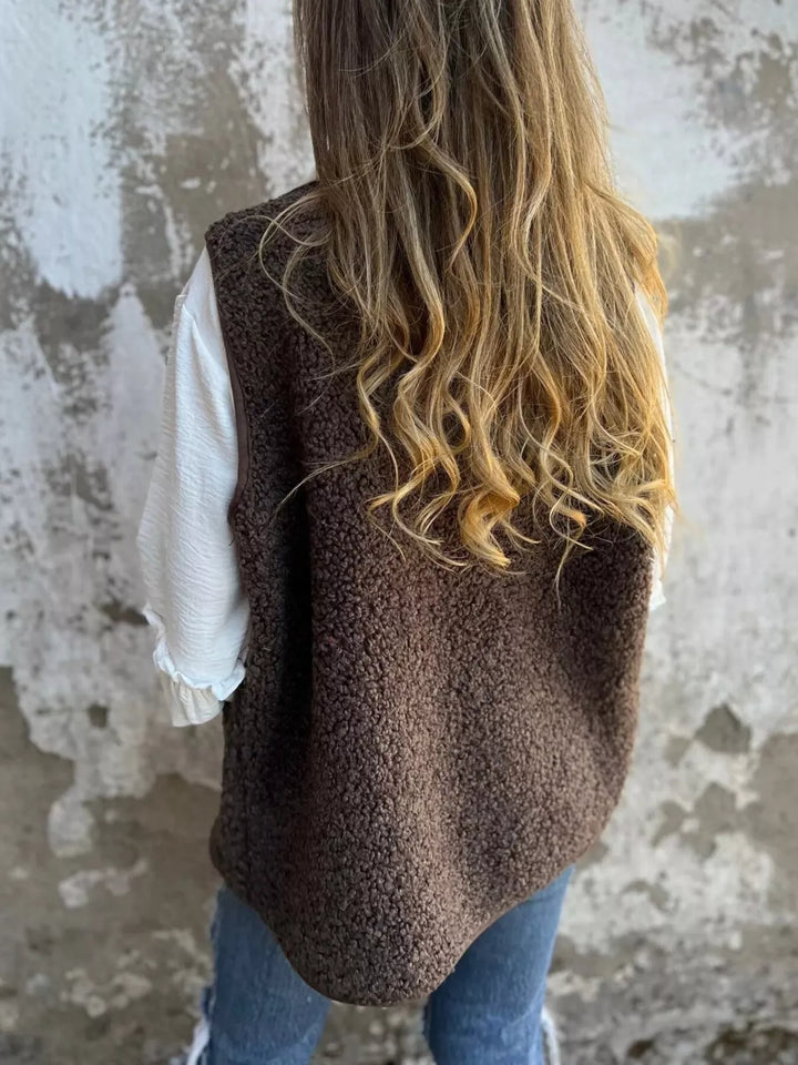 Back view of the mocha sleeveless textured vest with a hip length hem