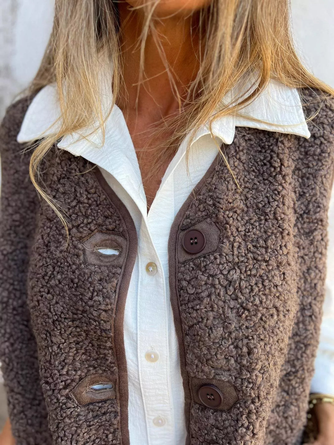 Close-up of the mocha fluffy vest buttons and textured front