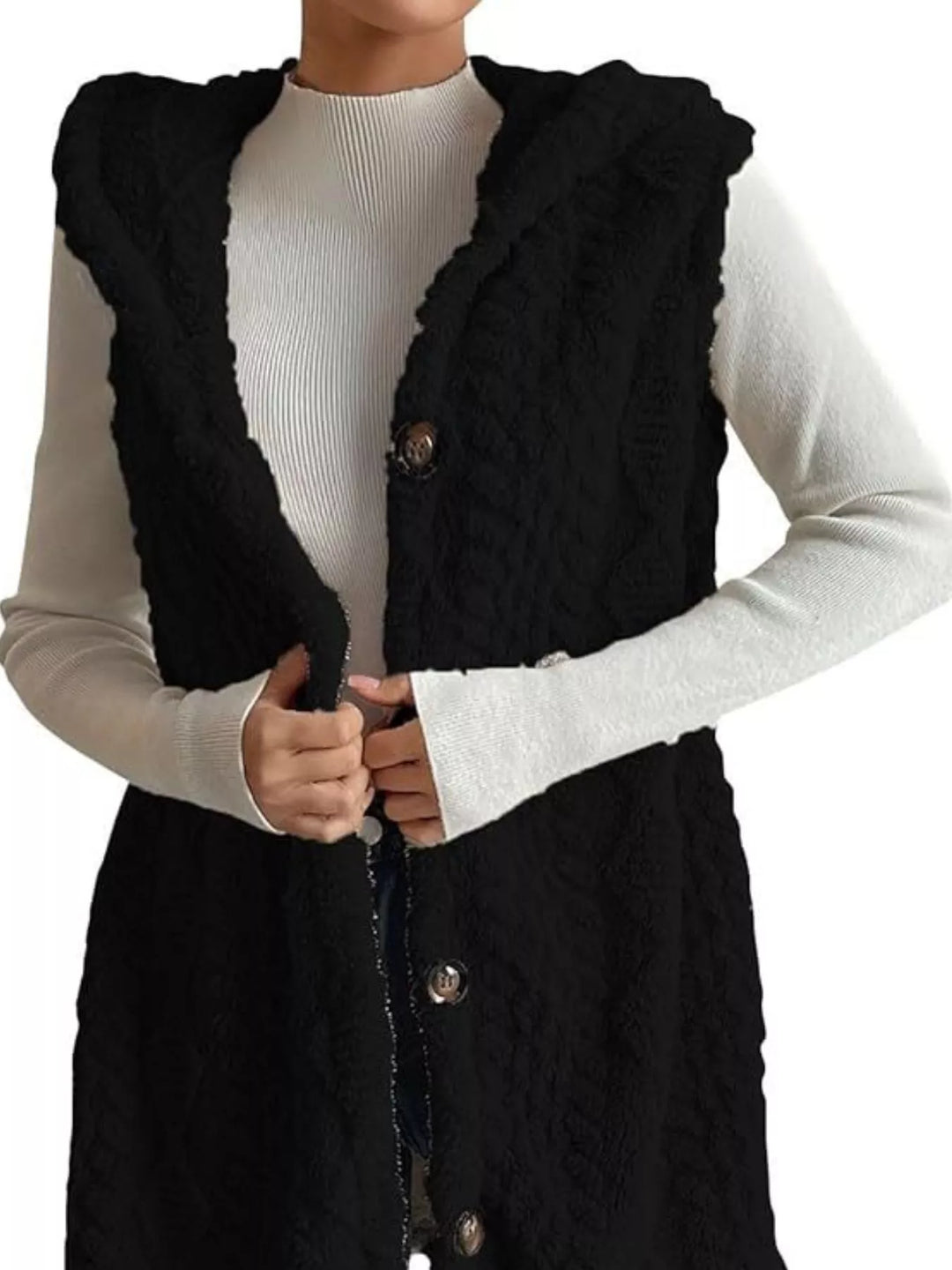Black cable knit hooded vest with hands holding the open front