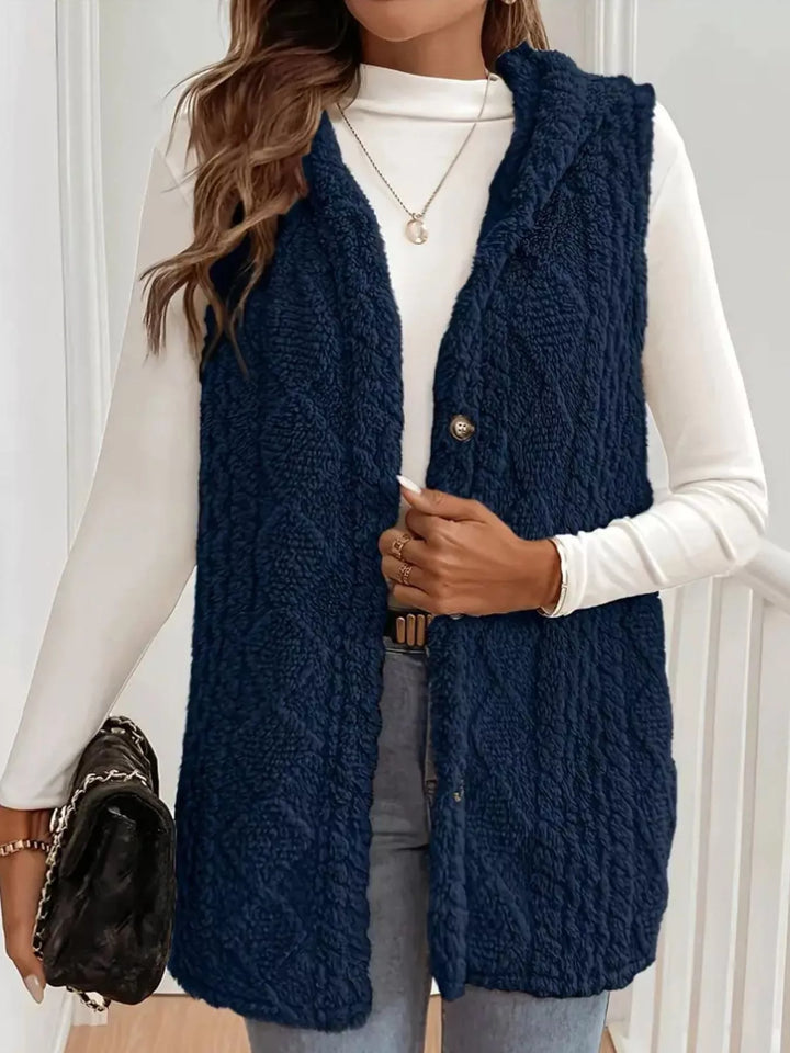 Navy hooded vest styled with a black handbag and light jeans