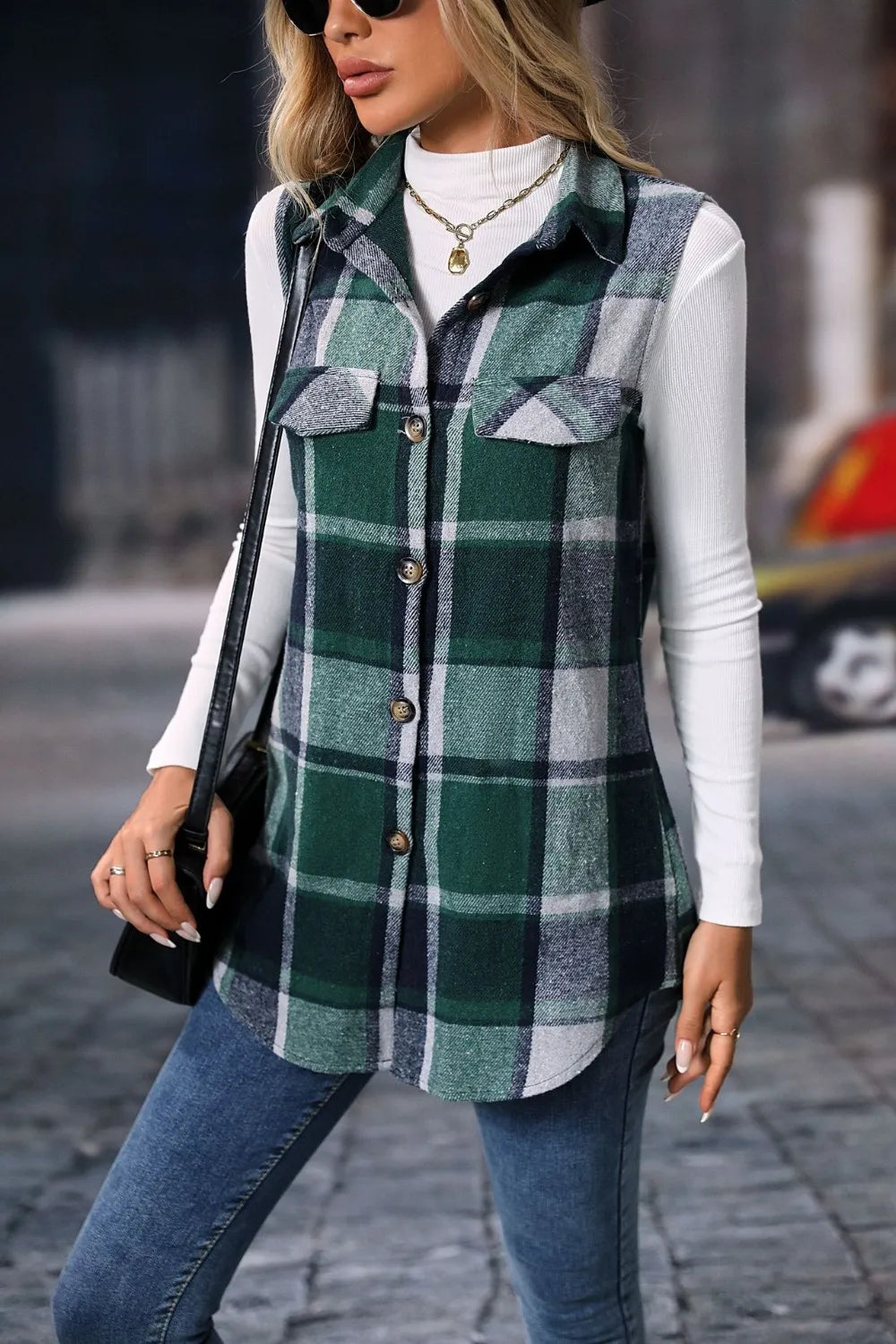 Dark green plaid vest with flap pockets worn over a white turtleneck