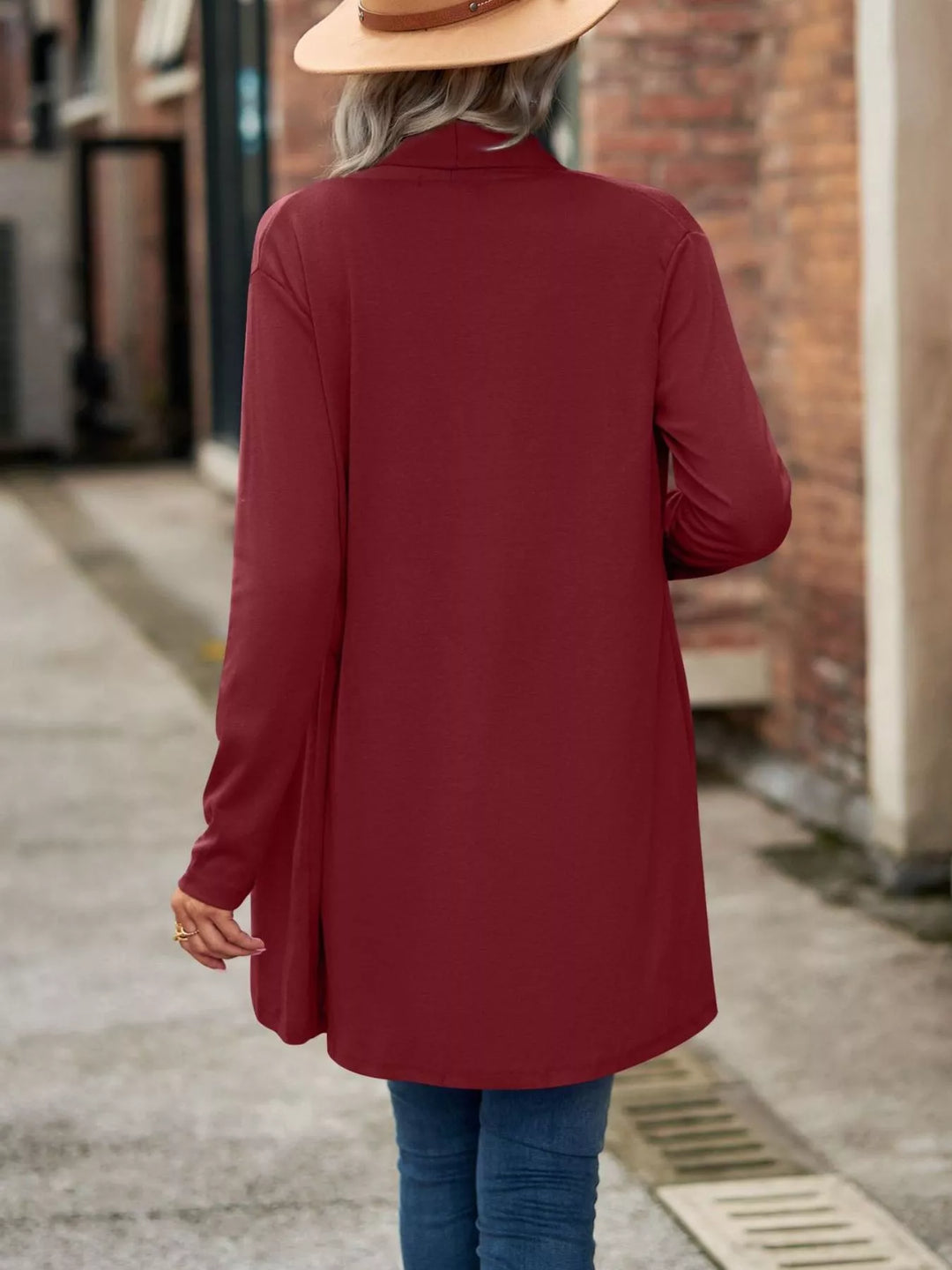 Back view of the burgundy long cardigan with curved hem