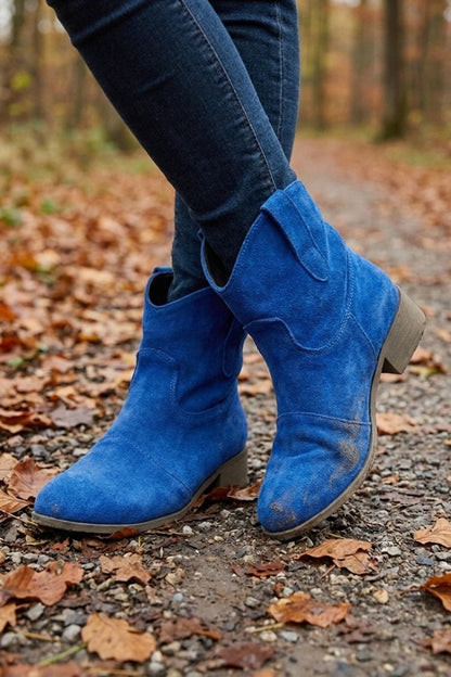 Blue suede-look western booties worn with jeans in autumn