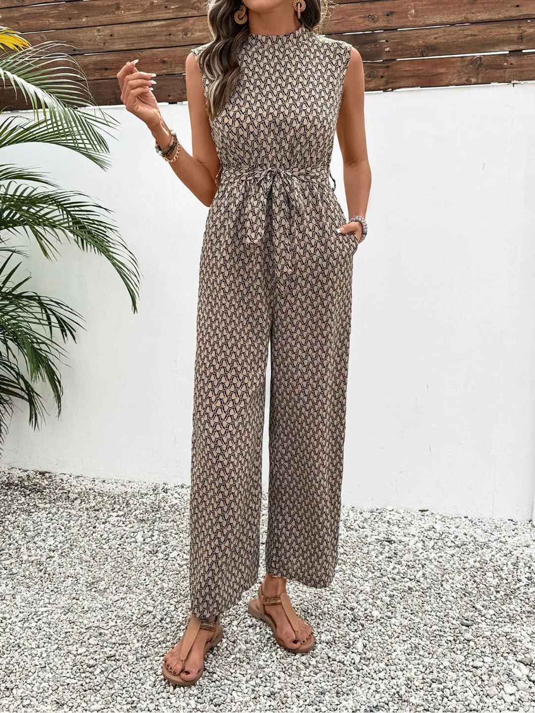 Standing pose in the taupe print wide leg jumpsuit with a hand in the pocket