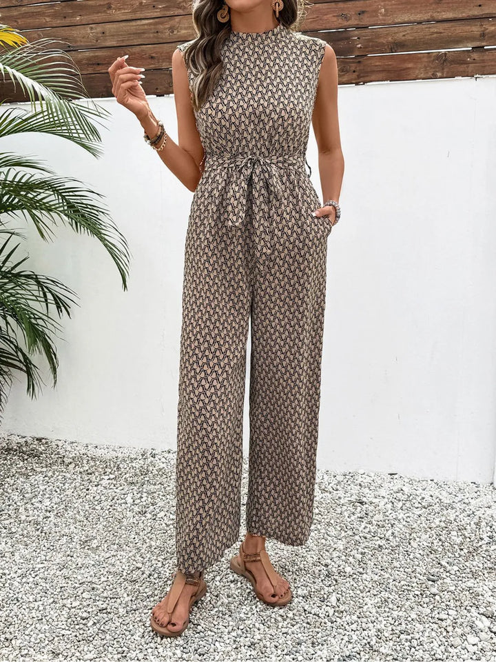 Standing pose in the taupe print wide leg jumpsuit with a hand in the pocket
