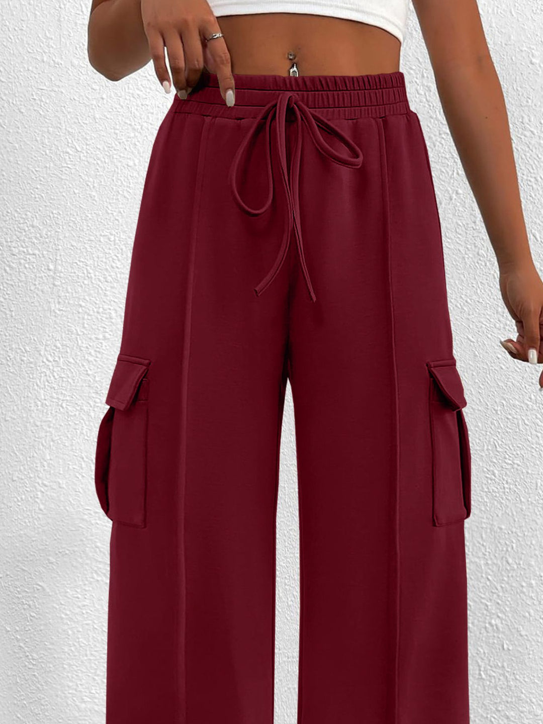 Close-up of the women's burgundy cargo pockets and drawstring waist