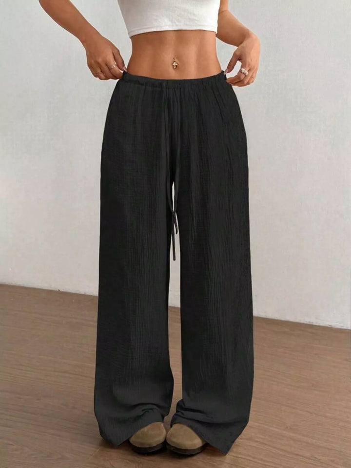 Black wide leg pants with drawstring waist, front view with cropped white top