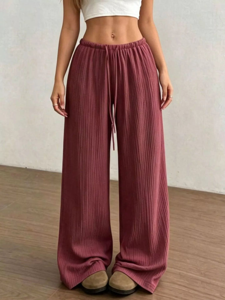 Full length burgundy wide leg pants showing the long relaxed hem
