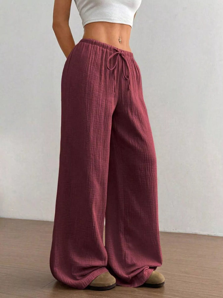 Burgundy drawstring wide leg pants seen from the side